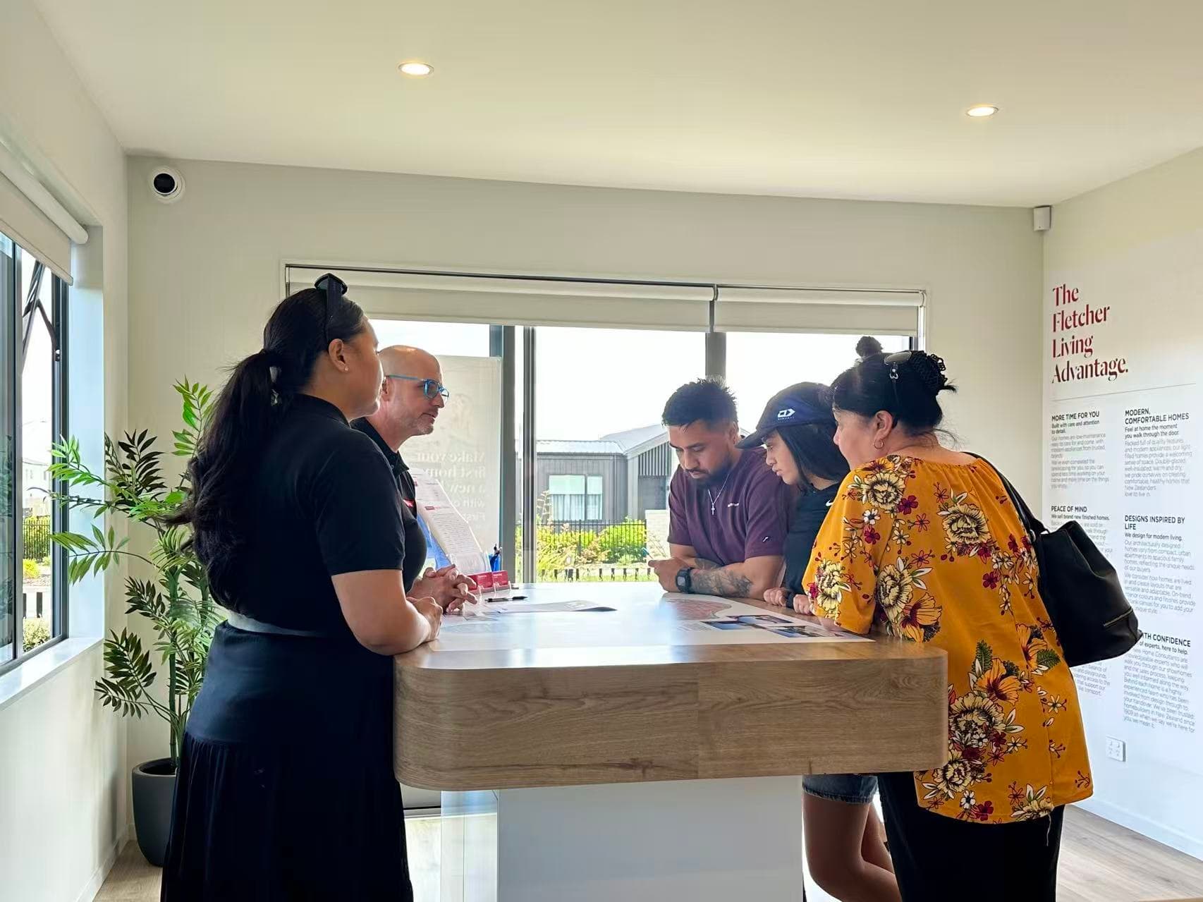 Visitors speaking with Fletcher Living staff during an Auckland open-home consultation