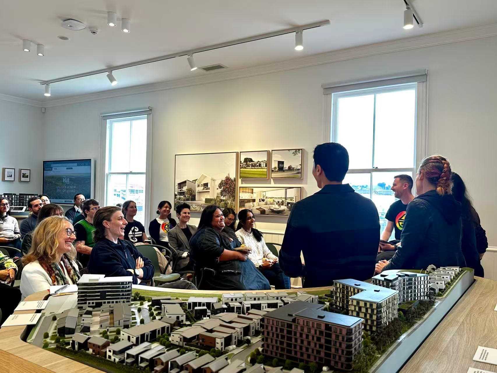 Audience and Fletcher Living team in a project information session with a residential scale model